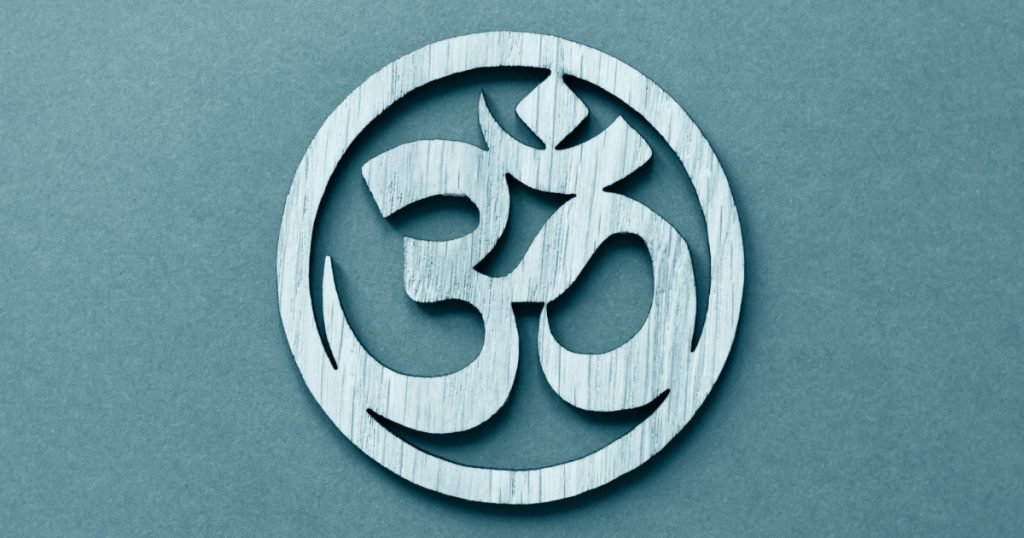 Om or Aum symbol of Hinduism and Buddhism on blue background
